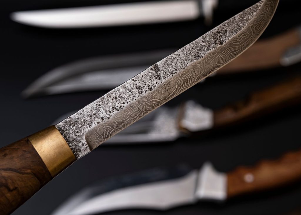 Artistic close-up view of vintage knife blades with textured surfaces and wooden handles, showcasing craftsmanship.